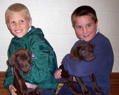 Maisy and Chip being held by their boys